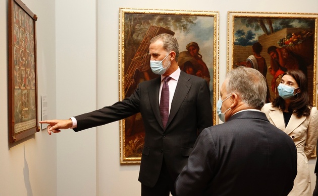 Su Majestad el Rey observa una de las obras en presencia de la ministra de Justicia y del comisario de la exposición